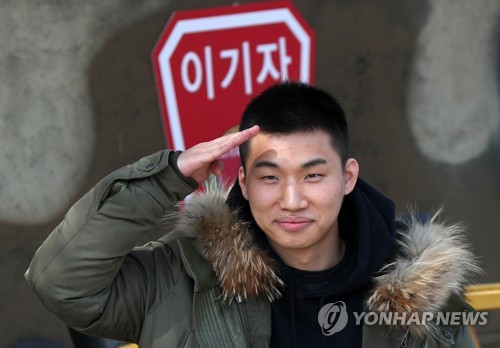 Daesung, singer of K-pop group BIGBANG, salutes fans before enlisting in the Army at the 27th Infantry Division base in Hwacheon, 118 kilometers northeast of Seoul, on March 13, 2018. (Yonhap)